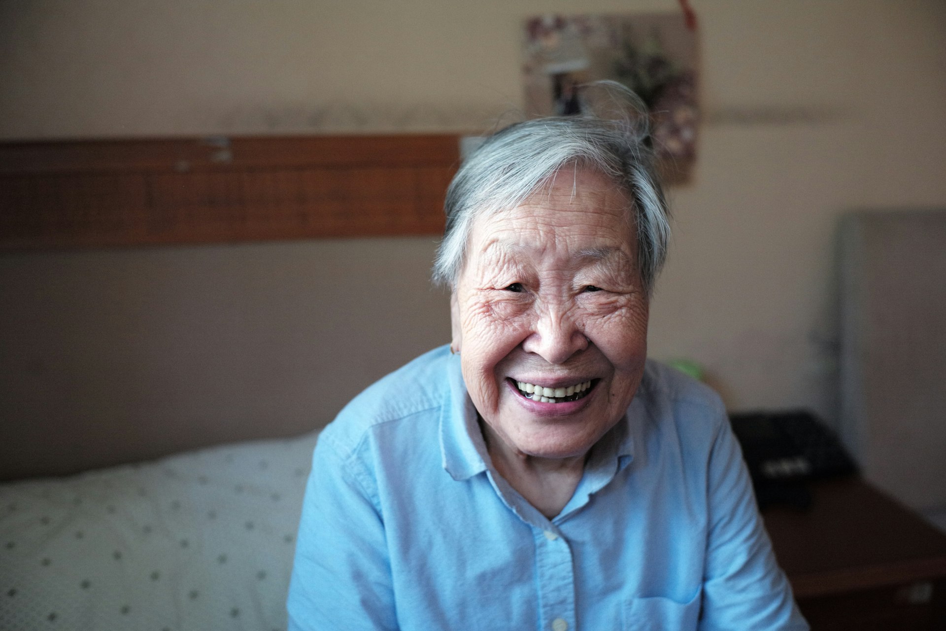 woman in blue button-down shirt smiling in front of camera